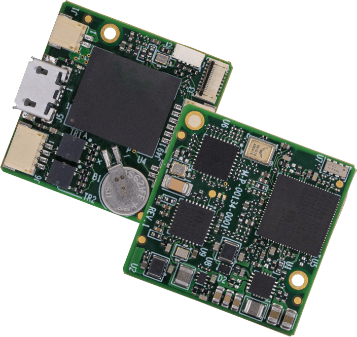 Two small green printed circuit boards with various electronic components, including microchips, capacitors, connectors, and a coin cell battery.