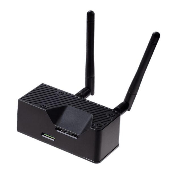 A small black electronic device with two antennas, ventilation grooves, and multiple ports, likely a wireless router or network device, shown on a plain white background.