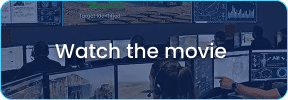 People sit in front of multiple computer monitors displaying various data from advanced Intelligence Gathering Systems, with “Watch the movie” text overlayed in the center.
